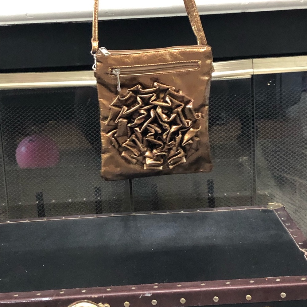 A dark gold bag with a rose design